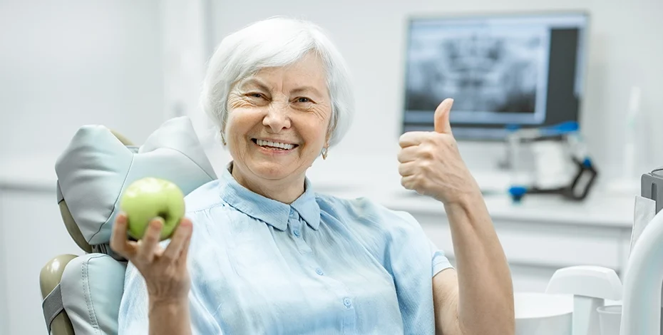 elderly woman smiling with new dentures