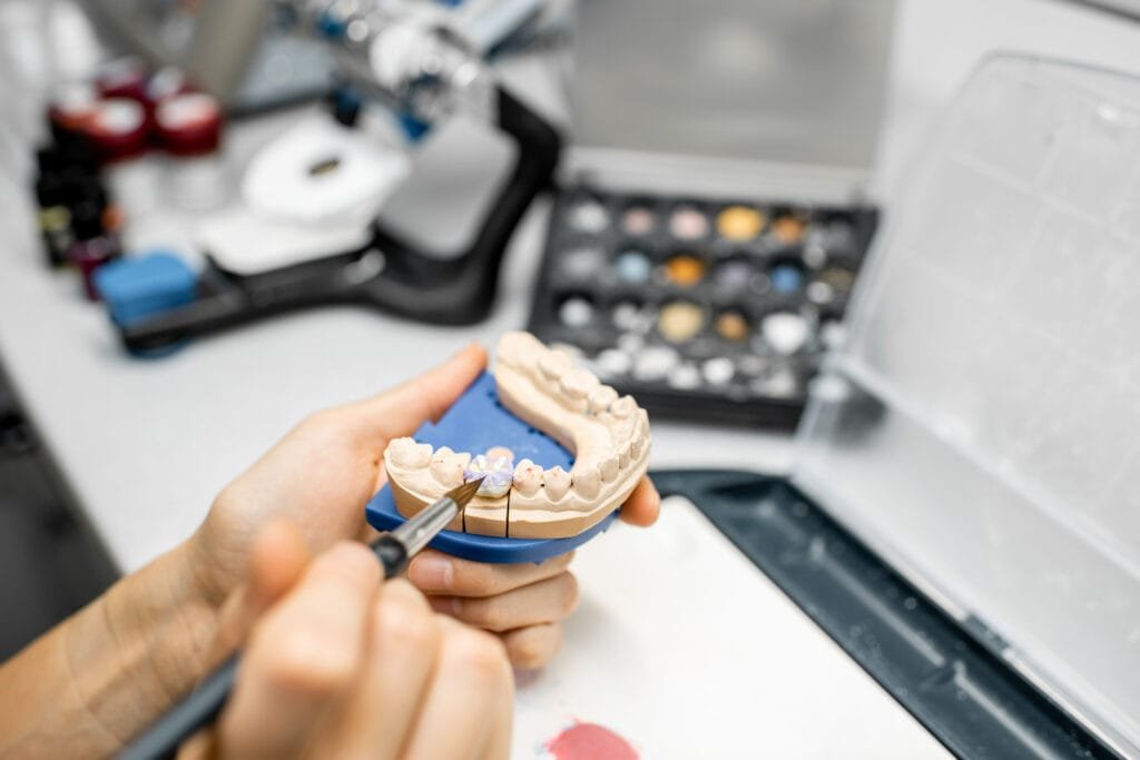 Dental technician repairing a denture in the laboratory